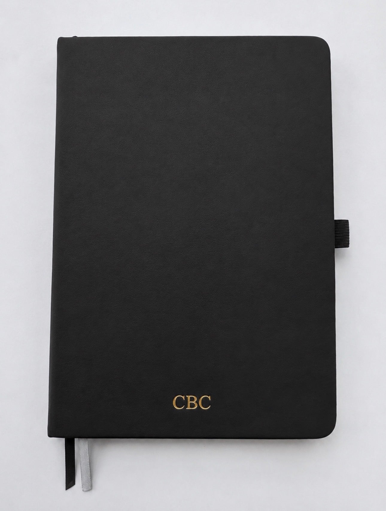 Personalized black leather journal with gold foil initials on an A5 hardcover notebook