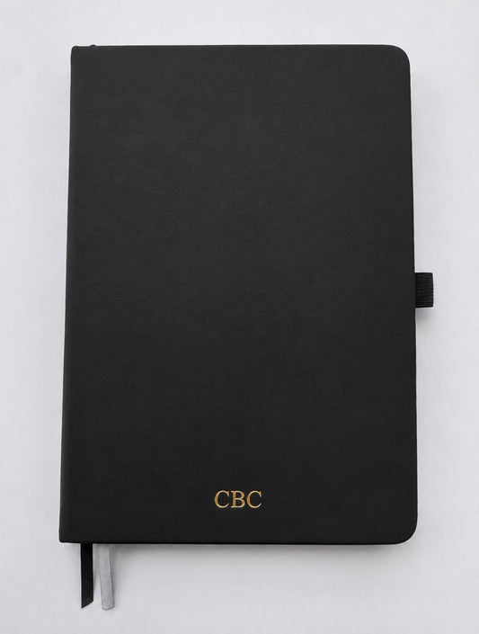 Personalized black leather journal with gold foil initials on an A5 hardcover notebook