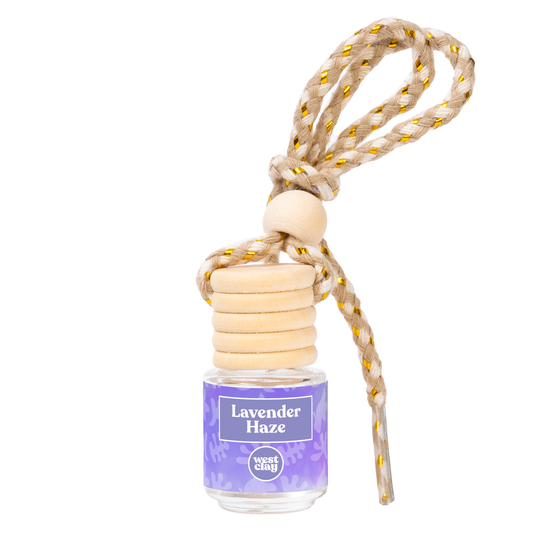 Small car oil diffuser hangs from rearview mirror in the scent lavender and vanilla
